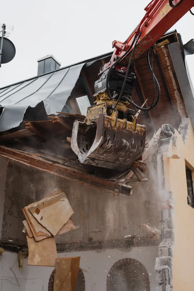 Bagger beim Hausabbruch und Dachrueckbau