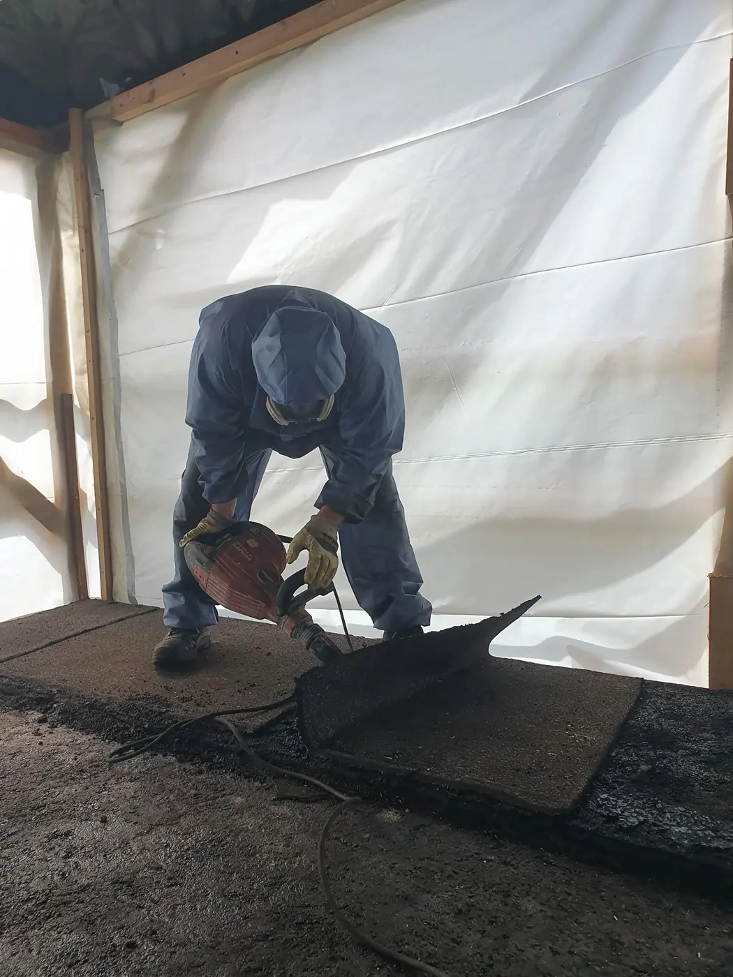 Facharbeiter beim Bodenaufbruch waehrend der Entkernung in einer Halle